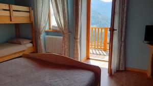 - une chambre avec des lits superposés et une grande fenêtre dans l'établissement B&B Blumenstube, à Sant’Orsola