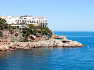 a building on top of a rocky island in the water at Apartament CCS 198 in Begur