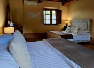 1 dormitorio con 2 camas y ventana en LaChiusa Tuscany en Montefollonico