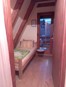 een kleine kamer met een bed en een raam bij Rooms Apartment Durmitor in Žabljak