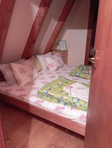 a bedroom with a bed with pink sheets and pillows at Rooms Apartment Durmitor in Žabljak
