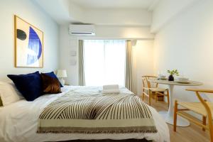 a bedroom with a bed and a table and a window at ZOOM江坂公園 - For long stay, Shin Osaka in Osaka