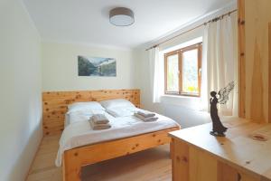 a bedroom with a wooden bed and a window at NaturparkResort Hobel`s Home in Wildalpen