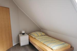 a small bedroom with a bed in a attic at Beekenhof in Bommelsen