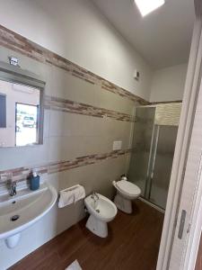a bathroom with a toilet and a tub and a sink at Park and House Sopramarzo in Bari