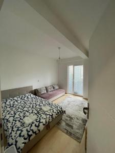 ein Schlafzimmer mit einem Bett und einem Sofa darin in der Unterkunft Cozy Apartment Therapy in Ohrid
