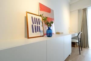 a white desk with a blue vase on top of it at ZOOM江坂公園 - For long stay, Shin Osaka in Osaka +63 photos