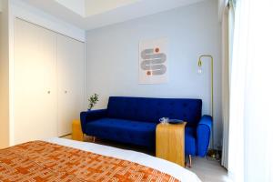 a blue couch in a room with a bed at ZOOM江坂公園 - For long stay, Shin Osaka in Osaka