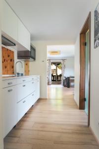a kitchen with white cabinets and a wooden floor at NaturparkResort Hobel`s Home in Wildalpen
