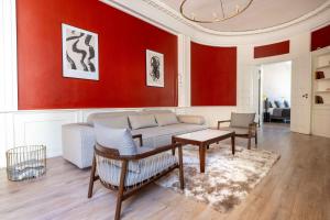 a living room with a couch and a red wall at Deluxe Apartment at Perfect Location in Copenhagen