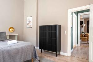 a bedroom with a bed and a black cabinet at Deluxe Apartment at Perfect Location in Copenhagen +55 photos