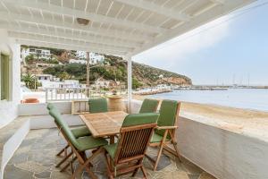 un tavolo e sedie su un balcone con vista sull'oceano di Sifnos Waterfront House a Platis Yialos Sifnos