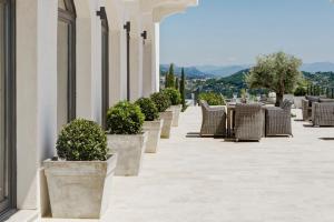 a row of planters with chairs and tables on a building at Maison Saint Christophe in Grasse