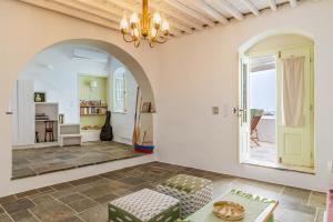 a living room with a couch and a chandelier at Sifnos Waterfront House in Platis Yialos Sifnos