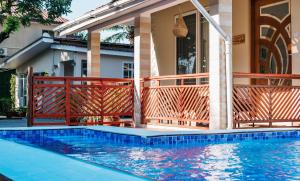 a house with a swimming pool in front of a house at The Amariah Hotel & Apartments Mikocheni in Dar es Salaam