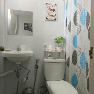 a bathroom with a toilet and a sink at Kings' Palms Residence02 in General Santos