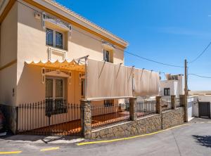 ein Haus mit einem Zaun davor in der Unterkunft Villa María Teresa in Málaga