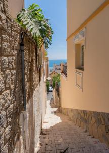 eine schmale Gasse zwischen zwei Gebäuden mit dem Meer im Hintergrund in der Unterkunft Villa María Teresa in Málaga