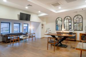 een woonkamer met een tafel, stoelen en een bank bij Iris Hotel in Tbilisi City