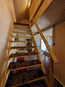 Una escalera de madera en una habitación con litera en Villa ALVIK en Geoagiu Băi