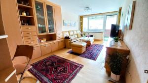 a living room with a couch and a table at PETER Seeblick Appartement Haus Hänsel Gretel am Ossiacher See, Hallenbad, Skiarena Gerlitzen in Unterberg