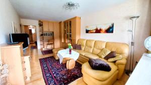 a living room with a couch and a table at PETER Seeblick Appartement Haus Hänsel Gretel am Ossiacher See, Hallenbad, Skiarena Gerlitzen in Unterberg