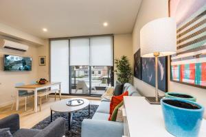 a living room with a couch and a table at Air Conditioned One Bedroom with Pool Close To CBD in Sydney