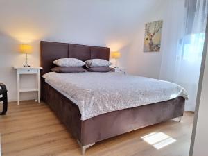 a large bed in a bedroom with two lamps on tables at Apartments Poljanak in Poljanak