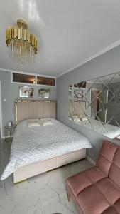 - une chambre avec un grand lit et un lustre dans l'établissement Gold Glamour Apartment Sopot z dwoma sypialniami, duzy balkon, à Sopot