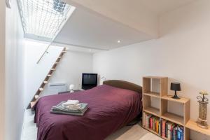 um quarto com uma cama e uma estante de livros em Le Sky - Les Alpilles em Eyguières