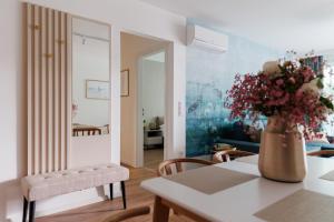 a living room with a vase of flowers on a table at Wave Luxury Apartment in Siófok +27 photos