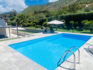 a swimming pool with a mountain in the background at Relaxing Villa Cefalù - Private Pool & Beach Walk by flAle's in Cefalù +25 photos