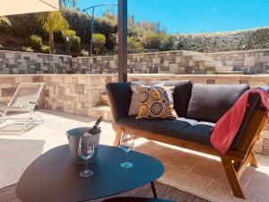 a couch on a patio with a table and wine glasses at Relaxing Villa Cefalù - Private Pool & Beach Walk by flAle's in Cefalù