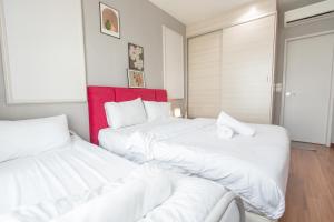 2 camas en una habitación con sábanas blancas en I Soho at I City by Bai Yi # 0933a, en Shah Alam