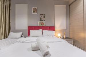 Un dormitorio con una cama blanca con toallas. en I Soho at I City by Bai Yi # 0933a, en Shah Alam