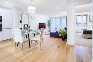 a dining room and living room with a table and chairs at Pluxa Moonstone Metropolis Luxury Getaway in Birmingham City Centre in Birmingham