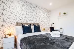 a bedroom with a large bed with blue pillows at Pluxa Moonstone Metropolis Luxury Getaway in Birmingham City Centre in Birmingham