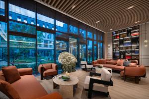 a lobby with couches and tables and windows at Holiday Inn Express Beijing Zhongguancun Tech Park by IHG l Next to The Old Summer Palace & Beijing Sport University l Taxi 10 Minutes to Summer Palace & Peking University & Tsinghua University in Beijing