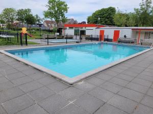 une grande piscine avec de l'eau bleue dans l'établissement Holiday Home Friesland near the Wadden Sea with Wifi and 3 Bedrooms, à Tzummarum