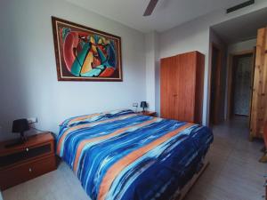 um quarto com uma cama e um quadro na parede em El rincón de Elia em L'Ampolla