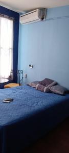 Cama en habitación con pared azul en Comfort Home Escalón en San Salvador