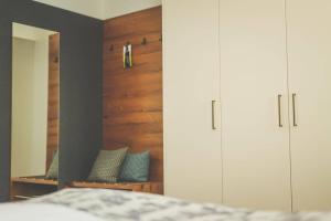 ein Schlafzimmer mit weißen Schränken und einem Spiegel in der Unterkunft Weingut & Gästehaus zum Seeblick - Familie Sattler in Jois