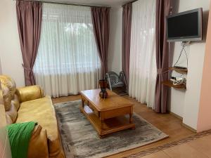 a living room with a couch and a coffee table at VILLA BY THE LAKE in Curtea de Argeş