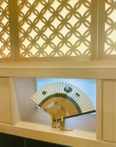 a painting of a fan on a shelf in a room at Kyoto Sanjo Ohashi in Kyoto