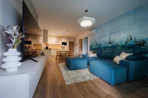 a living room with a blue couch and a blue wall at Wave Luxury Apartment in Siófok