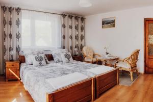 a bedroom with a bed and chairs and a window at Pokoje Marzena in Ochotnica Górna