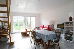 een woonkamer met een tafel en een rode bank bij EXIGEHOME - Maison à 2 pas de la foret - 30min de Versailles in Vélizy-Villacoublay