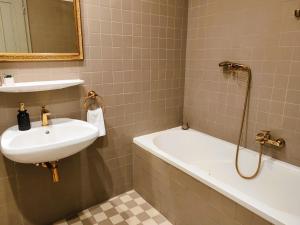 y baño con lavabo y bañera. en Városi Vendégház Szentendre en Szentendre