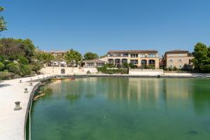 ein großer Wasserpool mit Gebäuden im Hintergrund in der Unterkunft T2 Accès direct golf et piscine in Mallemort