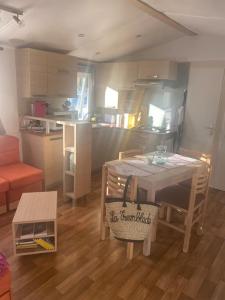 Una sala de estar con una mesa y una cocina. en Bungalow à Ronce les Bains, en La Tremblade 4 fotos más